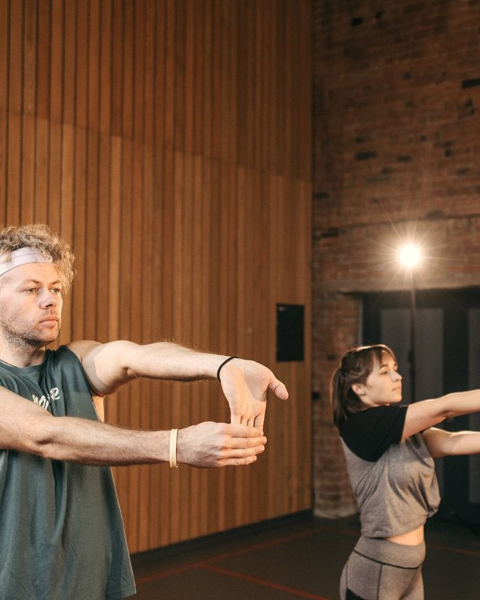 Group stretching in a wood-clad studio
