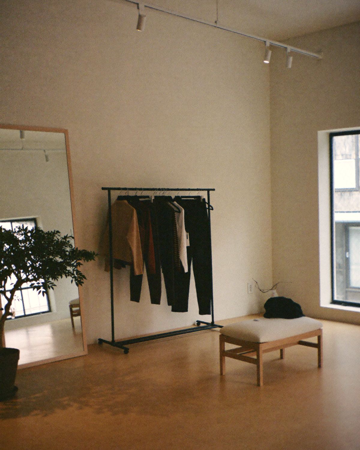 A szöuli showroom: világos fa, egyetlen ruhaállvány, álló tükör és lenvászon pad