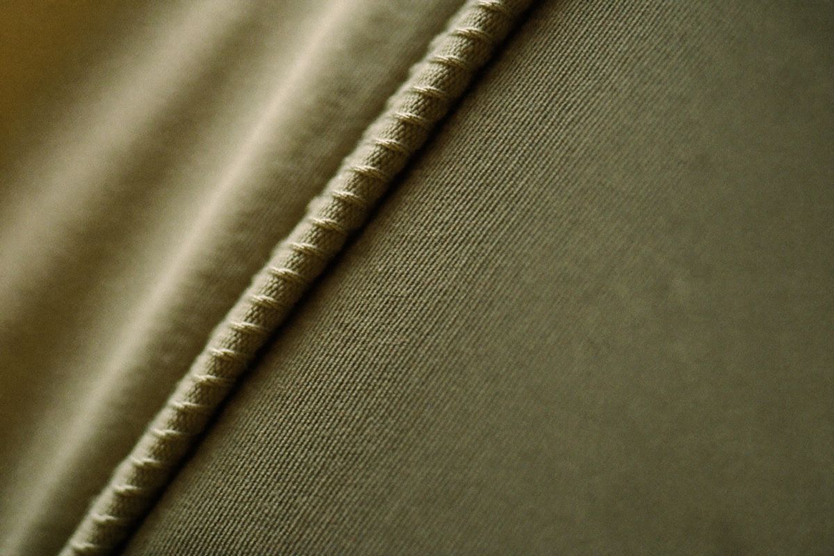 Macro of a flatlock seam on sage technical fabric in raking light